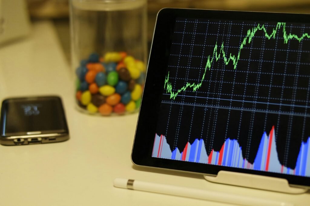 pexels-photo-186464-186464 Tablet display of stock market data with smartphone and colorful candies on desk.