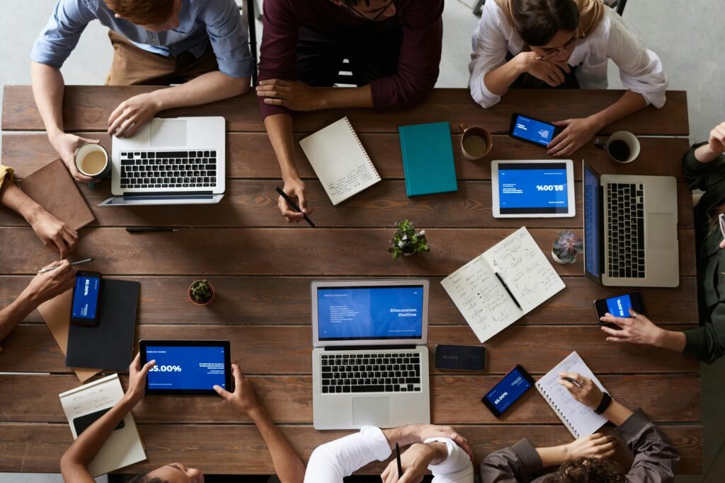 pexels-photo-3183150-3183150 Overhead view of a diverse team in a business meeting using laptops and tablets.