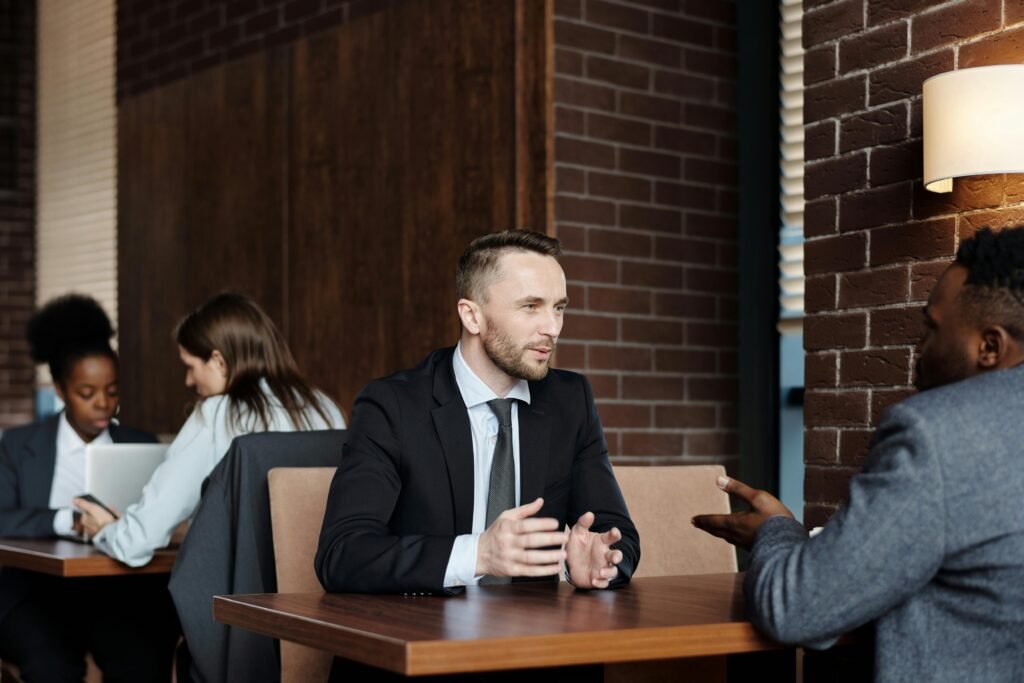 pexels-photo-4427905-4427905 Businessmen engaged in a professional conversation in a stylish café setting.